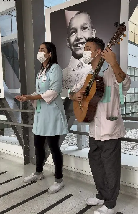 Cantora e violonista cantam juntos numa passarela do GRAACC