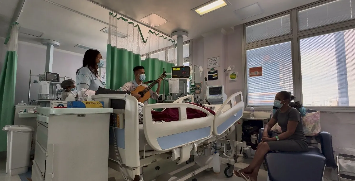 Dupla de artistas toca violão e canta num quarto de internação do Instituto da Criança