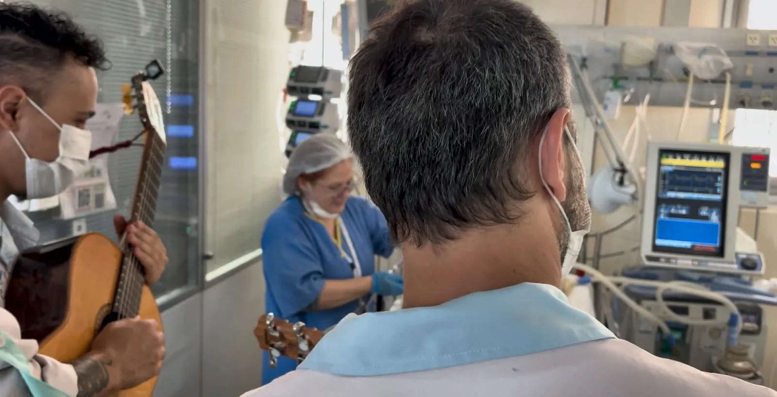Artista toca para uma profissional de enfermagem durante o trabalho